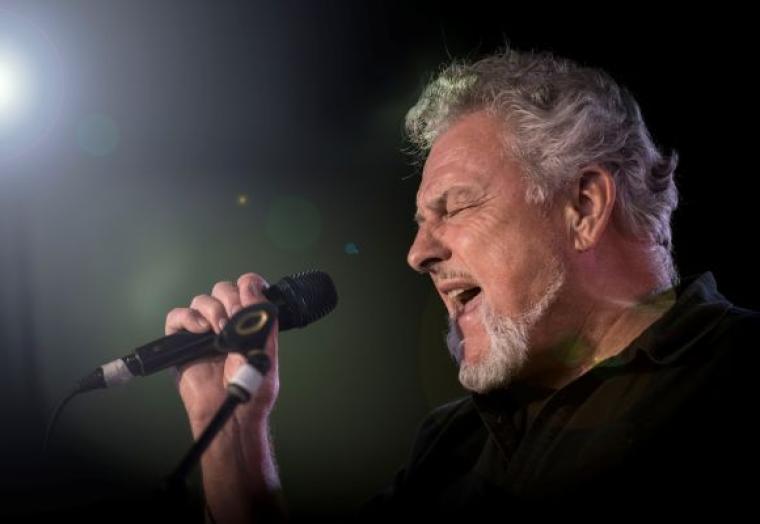 A man sings into a microphone