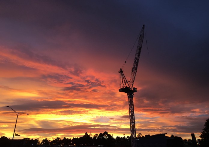 An image of a building crane set against a sunset. 