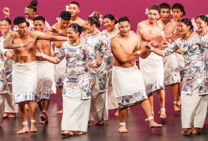 Young people dancing on stage in traditional costume 