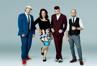 Four musicians stand in a line. 